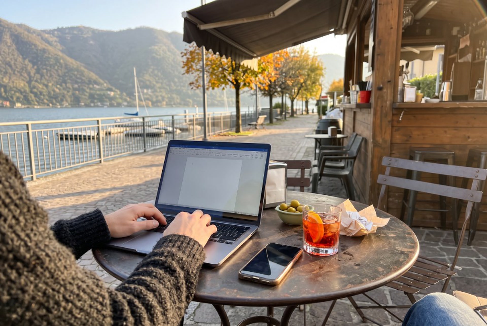 Laptop e aperitivo al chiosco sul lungolago